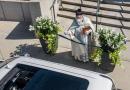 Sacerdote ripreso a spruzzare acqua santa con una pistoletta ad acqua.