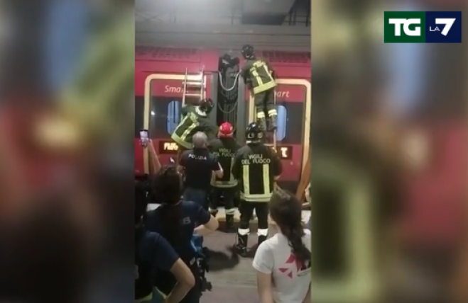 Viaggia sul soffietto che unisce i due vagoni del treno
